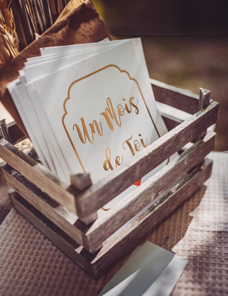 Mise en situation dans une cagette en bois des 18 cartes étapes première année pour bébé dorées