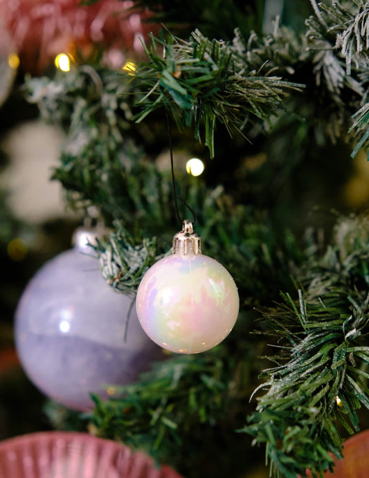 Mise en situation dans un sapin du lot de 18 mini boules de Noël blanches pailletées et mates