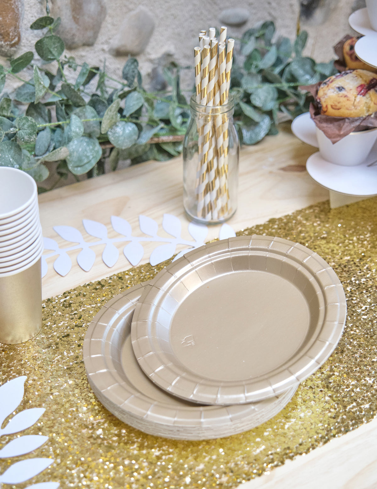 Mise en scène sur une table des petites assiettes en carton pour fête doré mat
