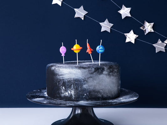Mise en situation sur un gâteau des 4 bougies d'anniversaire astronaute fusée et planète