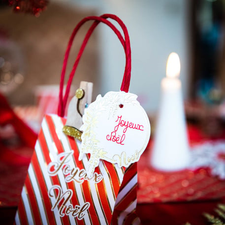 Détail de l'anse et de l'étiquette des sacs en carton Joyeux Noël pour chocolats