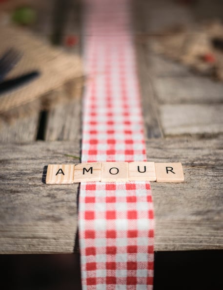 Mot AMOUR sur un chemin de table vichy des 60 lettres alphabet façon scrabble pour décoration de table en bois