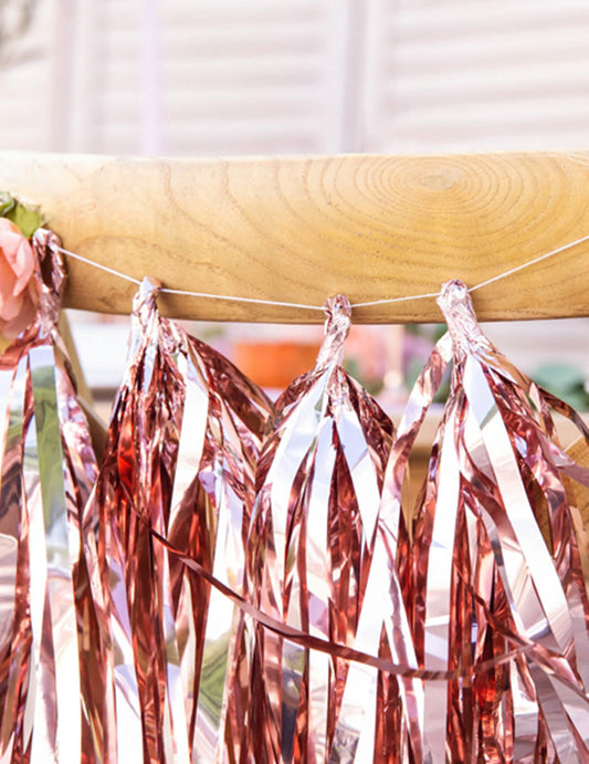 Gros plan sur les pompons de la guirlande tassel 12 pompons pour décoration de fête rose gold métallisé