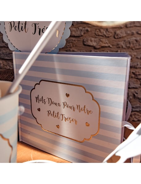Gros plan sur le lettrage doré du livre d'or petit trésor pour baby shower