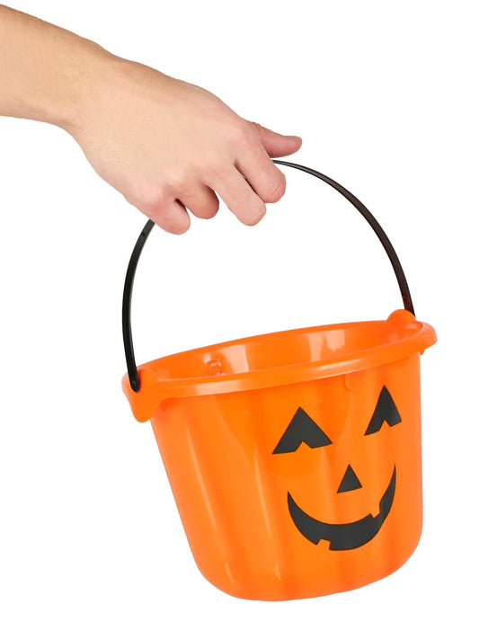 Detail des von einer Hand gehaltenen Griffs des Kürbis-Eimers für Halloween