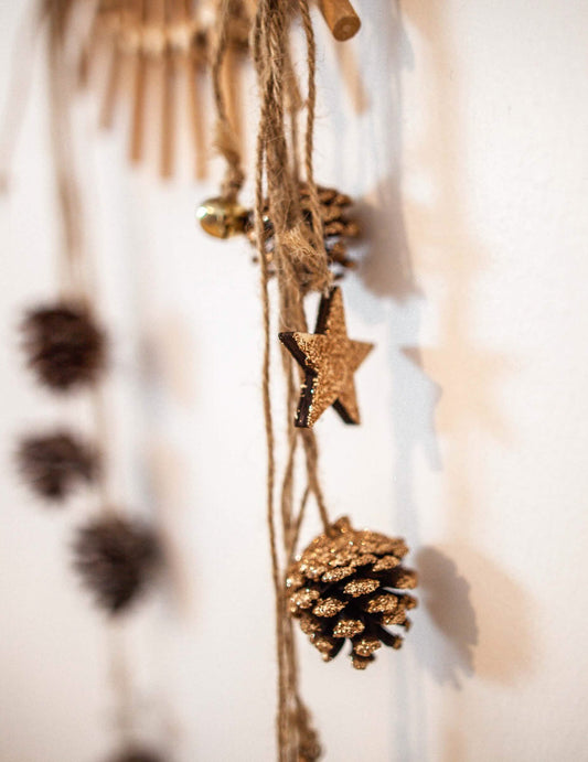 Détail de l'étoile et des paillettes de la suspension pommes de pin et étoiles bois pour décoration paillettes cuivre