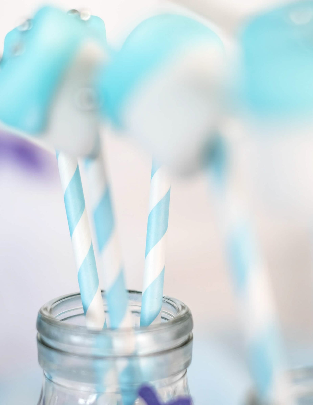 Gros plan sur le motif des pailles en carton rayées bleu pastel