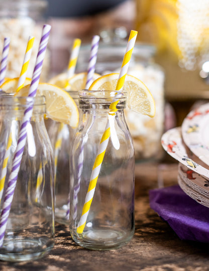 Mise en scène festive sur une table des pailles en carton rayées pour cocktails