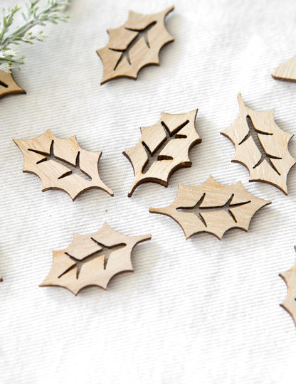 Vue rapprochée des confettis en bois ajouré feuilles de houx pour noël