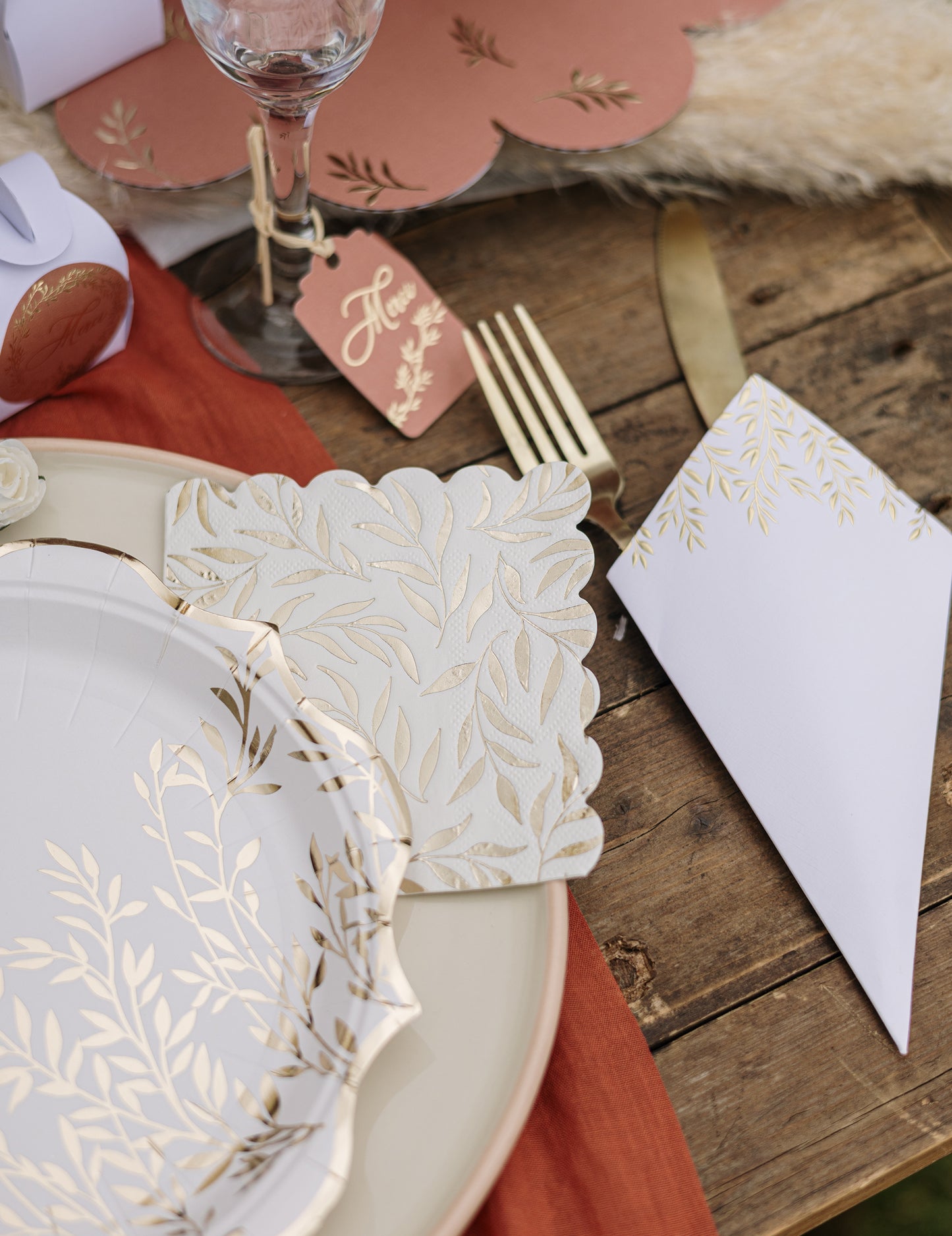 Mise en situation de table des serviettes cocktail en papier à motif feuillage festonné blanc et or
