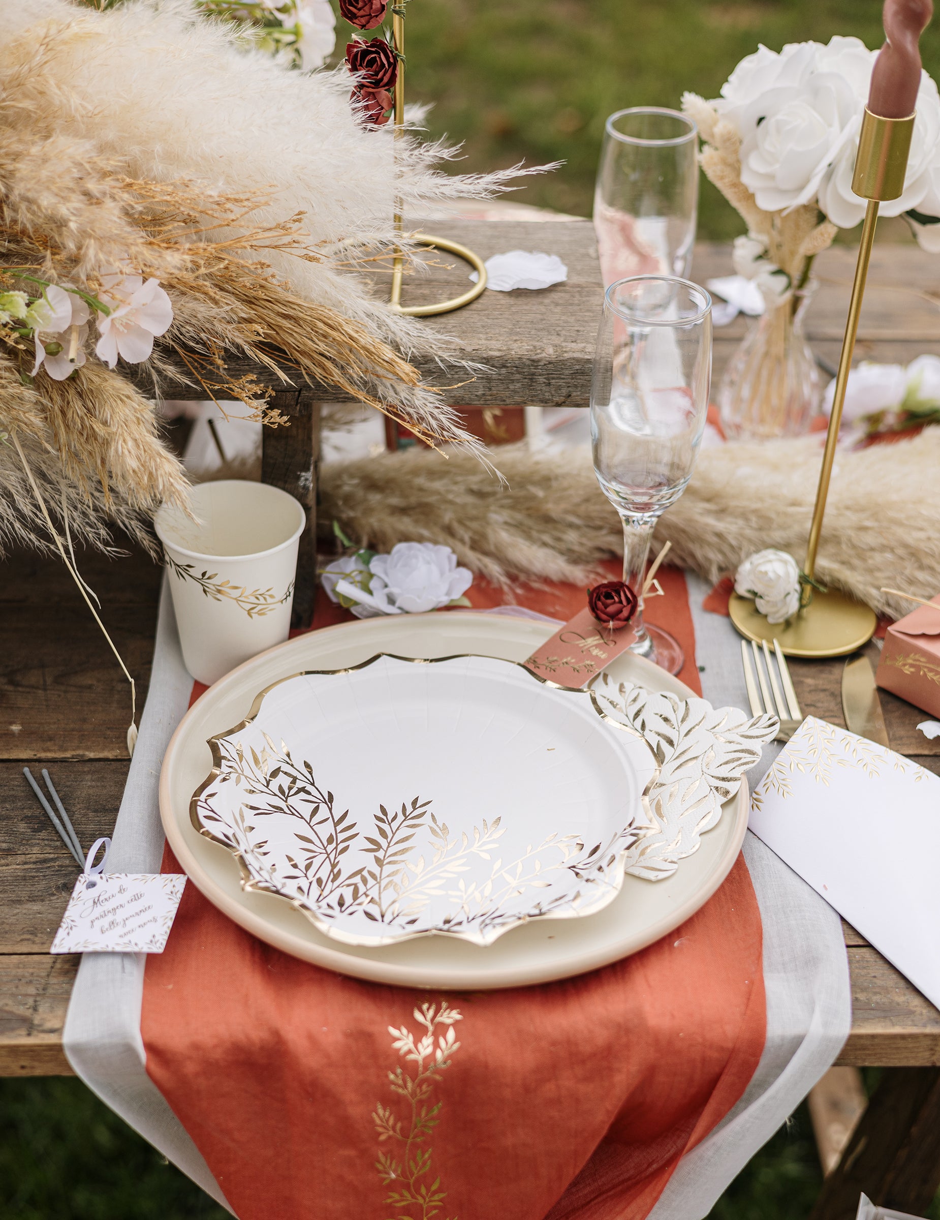 Gros plan sur le dressage de table des serviettes cocktail en papier à motif feuillage festonné blanc et or