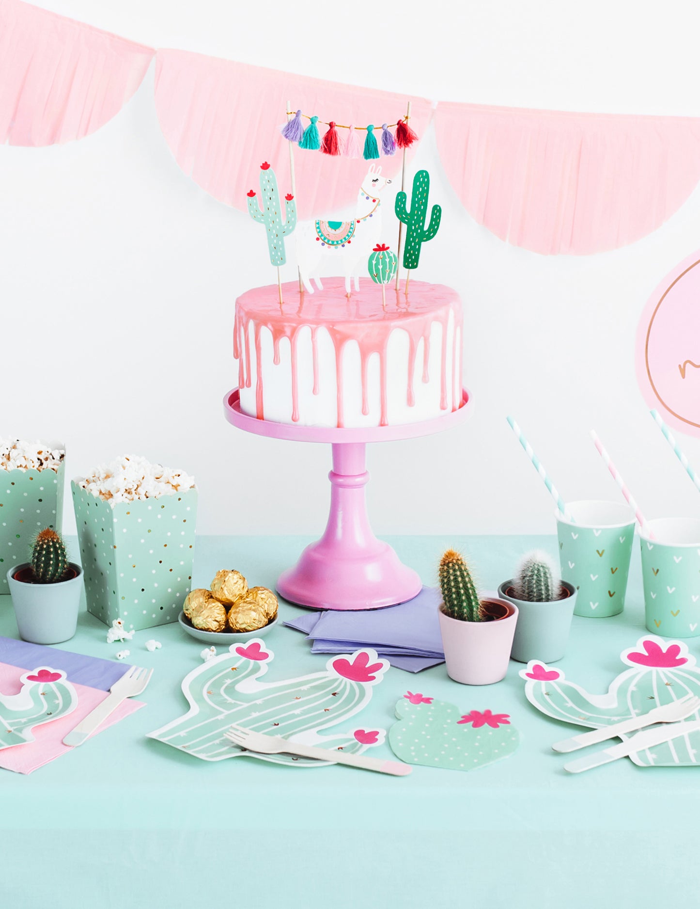 Mise en situation sur une table de fête des serviettes en papier cactus menthe et fuchsia