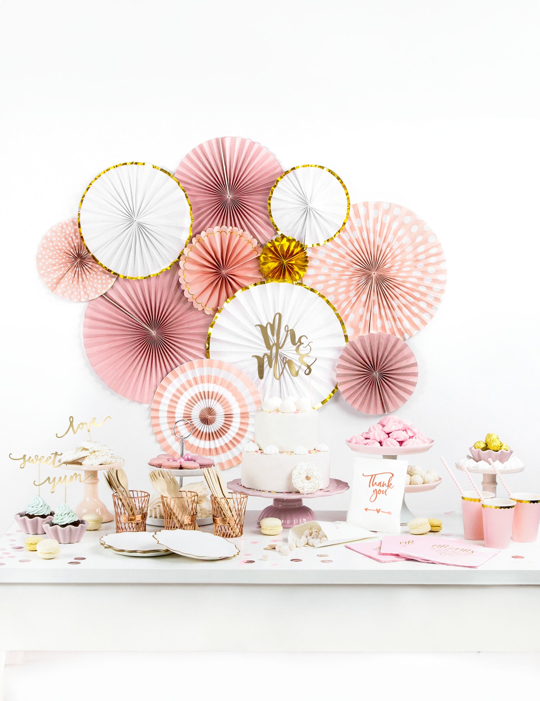Mise en situation sur un buffet de fête des 3 rosaces en carton rose poudré et or