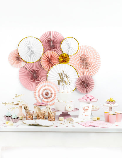 Mise en situation sur un buffet de fête des 3 rosaces en carton rose poudré et or