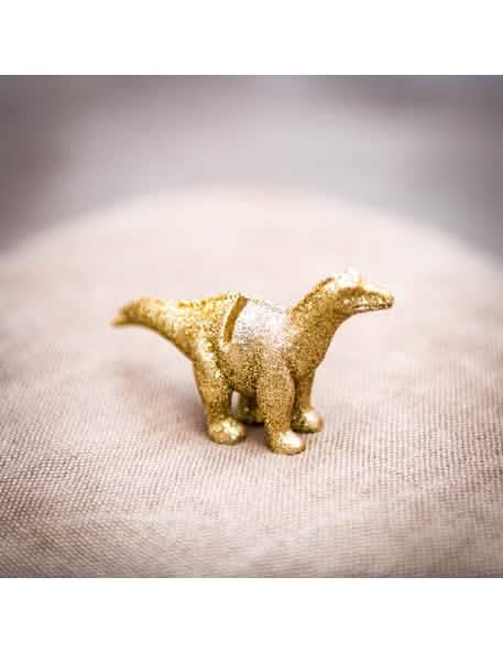 Nahaufnahme der goldenen Glitzerpartikel des Platzhalters aus Harz Dinosaurus