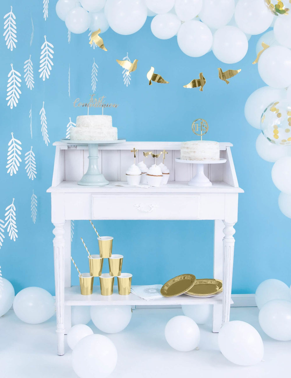 Mise en scène sur buffet blanc des habillages à cupcakes en papier pour mariage