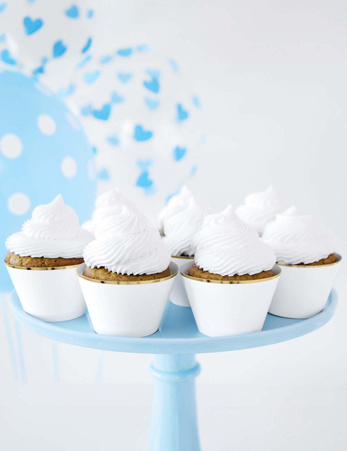 Mise en scène avec ballons bleus des habillages à cupcakes en papier pour mariage