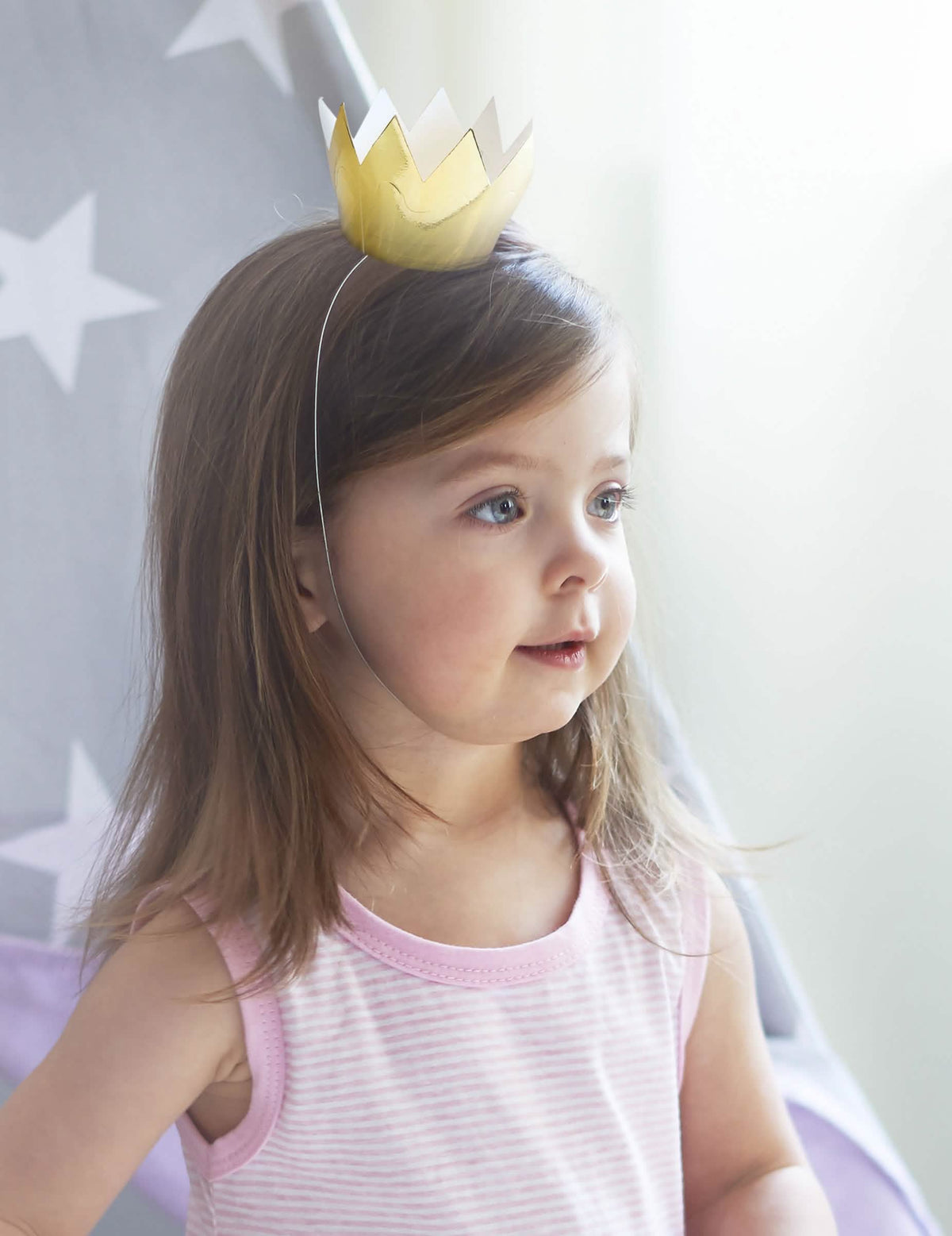 Vue portée par un enfant des 6 mini couronnes dorées pour fête en carton brillant