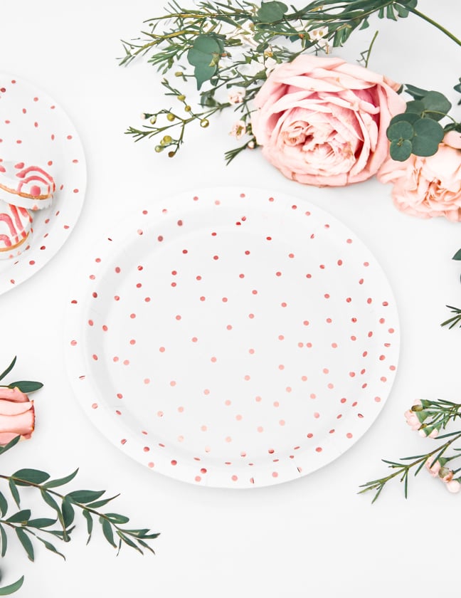 Vue de dessus des assiettes en carton à pois pour table blanches et rose gold