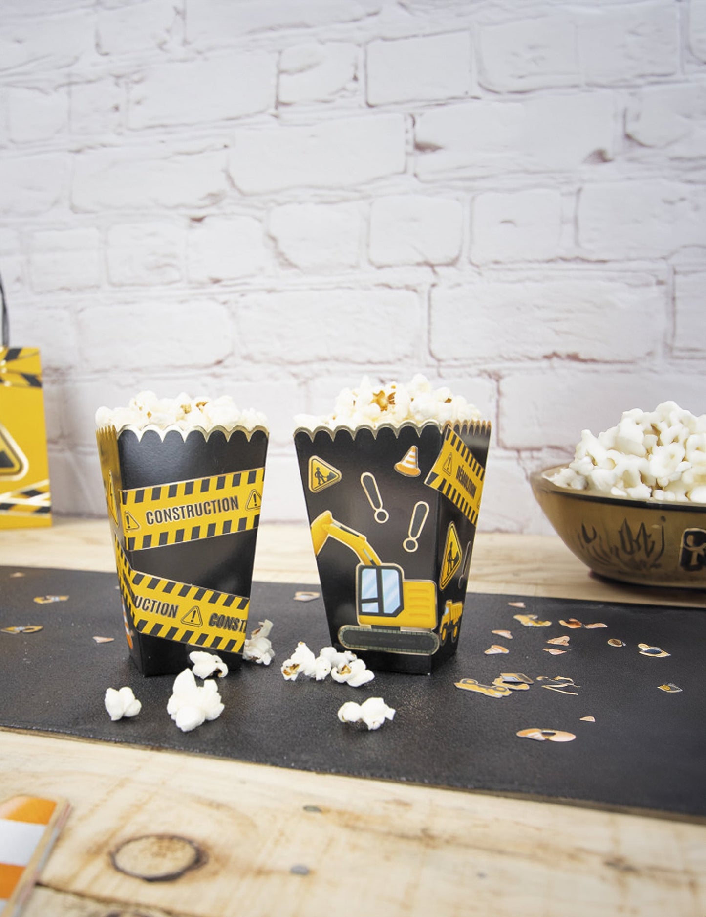 Gros plan sur les motifs de chantier des boîtes à pop-corn festonnées pour fête noires et or