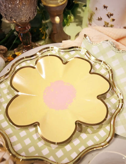 Détail de la superposition des petites assiettes fleurs lilas rose jaune vert et or en carton