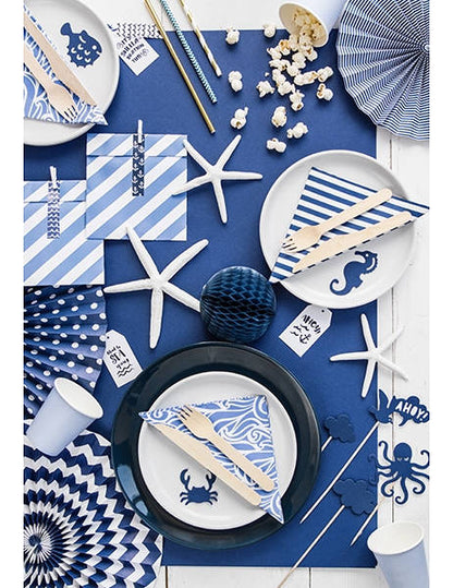 Mise en situation sur une table de fête des décorations pour gâteau sur pique motifs mer bleu marin