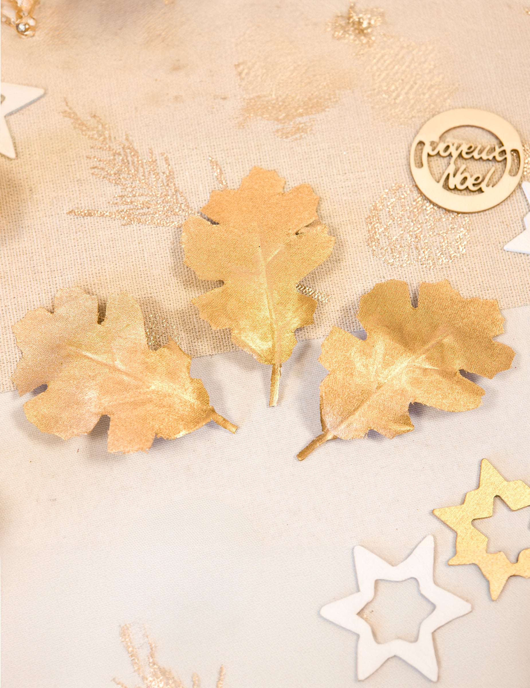 Mise en situation de trois feuilles de chêne en tissu métallisé pour décoration dorées
