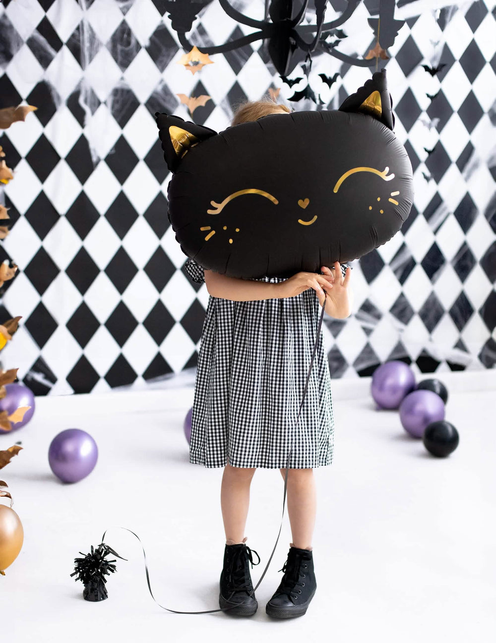 Enfant tenant devant son visage le ballon aluminium chat pour Halloween