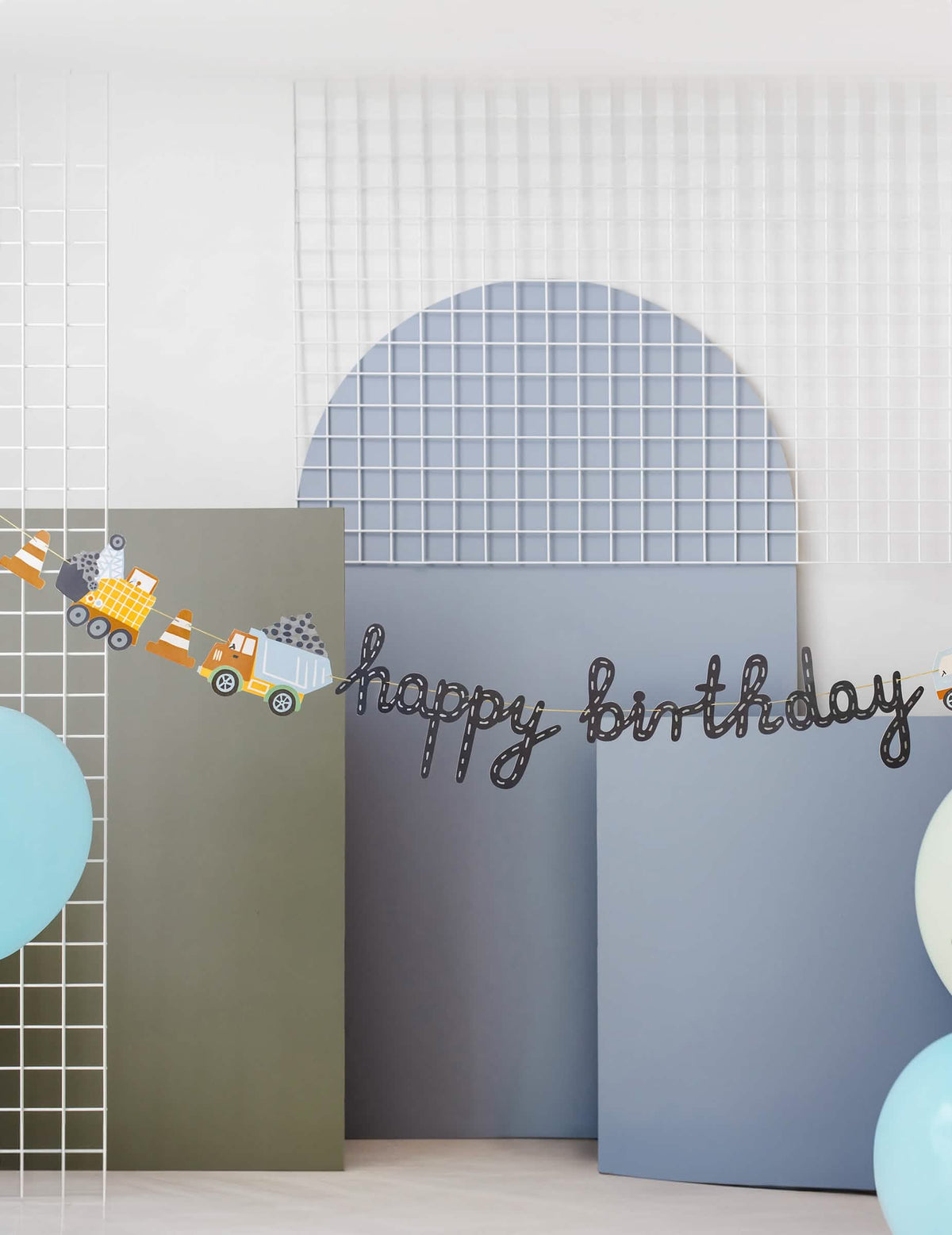 Gros plan sur l'inscription et les engins de la bannière Happy Birthday camions de chantier