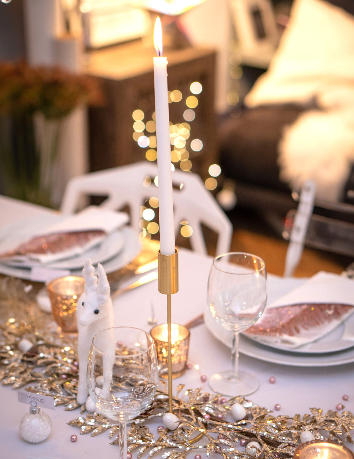 Mise en situation sur une table festive du bougeoir design sur pied pour table métal doré