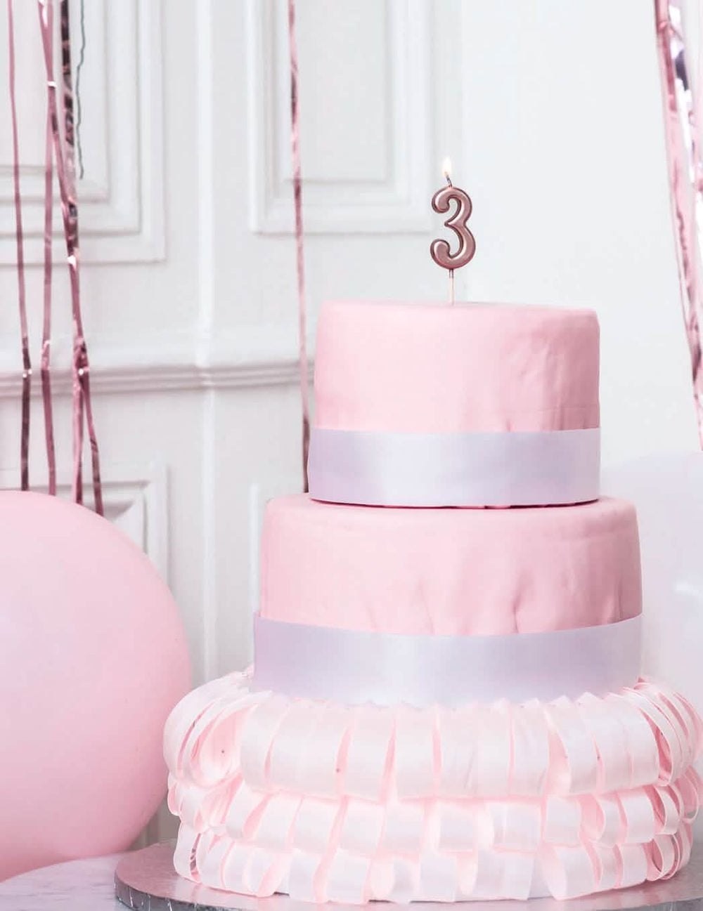 Mise en situation sur un gâteau de la bougie d'anniversaire chiffre 3 rose gold métallisée avec pic