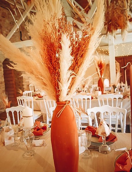 Mise en situation en centre de table du bouquet de broom séché terracotta pour décoration de fête orange