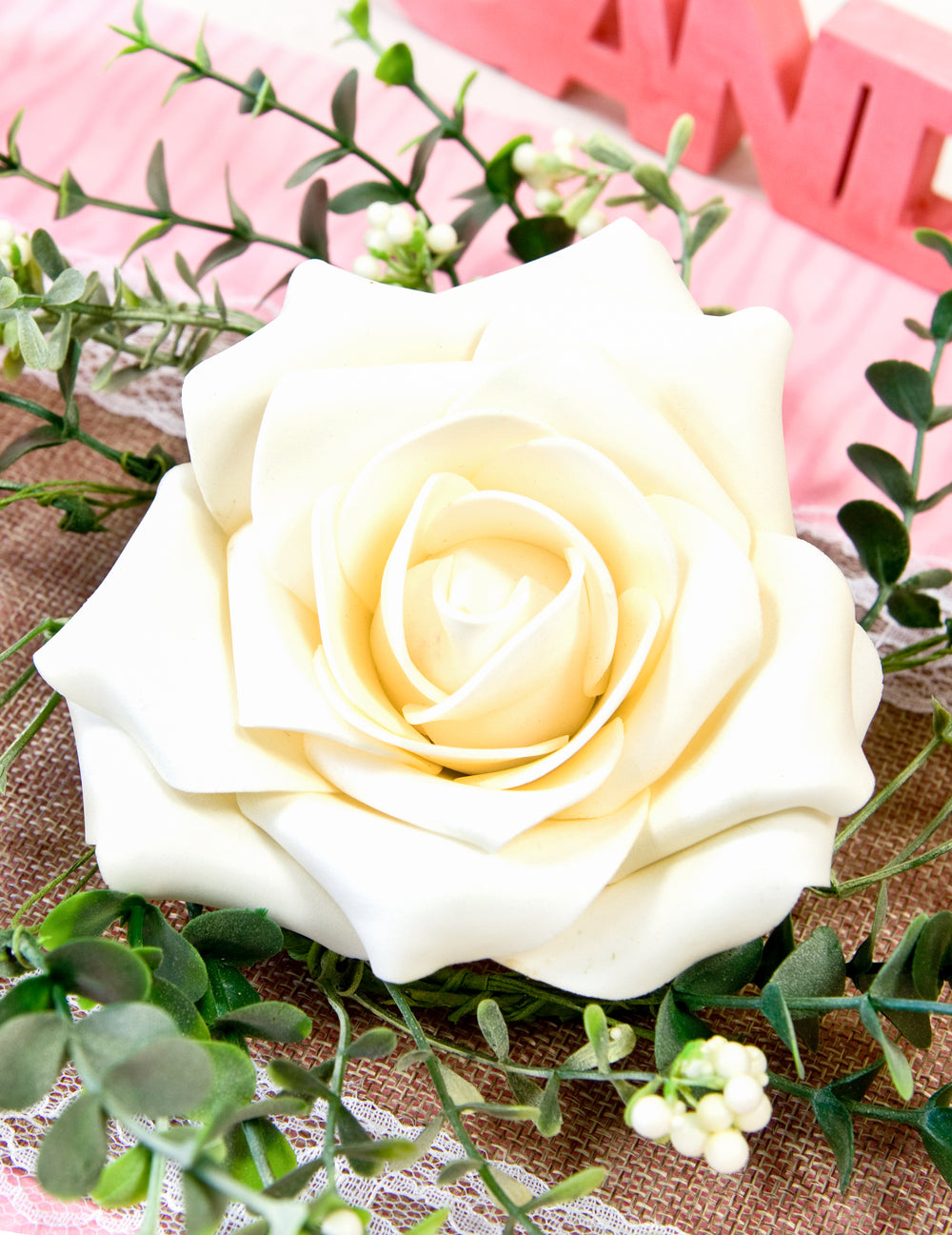 Gros plan sur la rose du centre de table rose et feuillage pour mariage champêtre