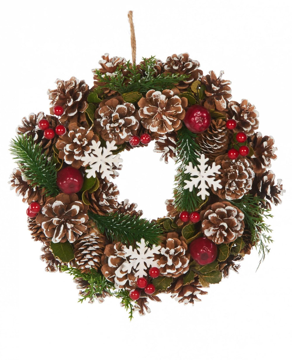 Couronne de Noël traditionnelle pour décoration avec pommes de pin et baies rouges
