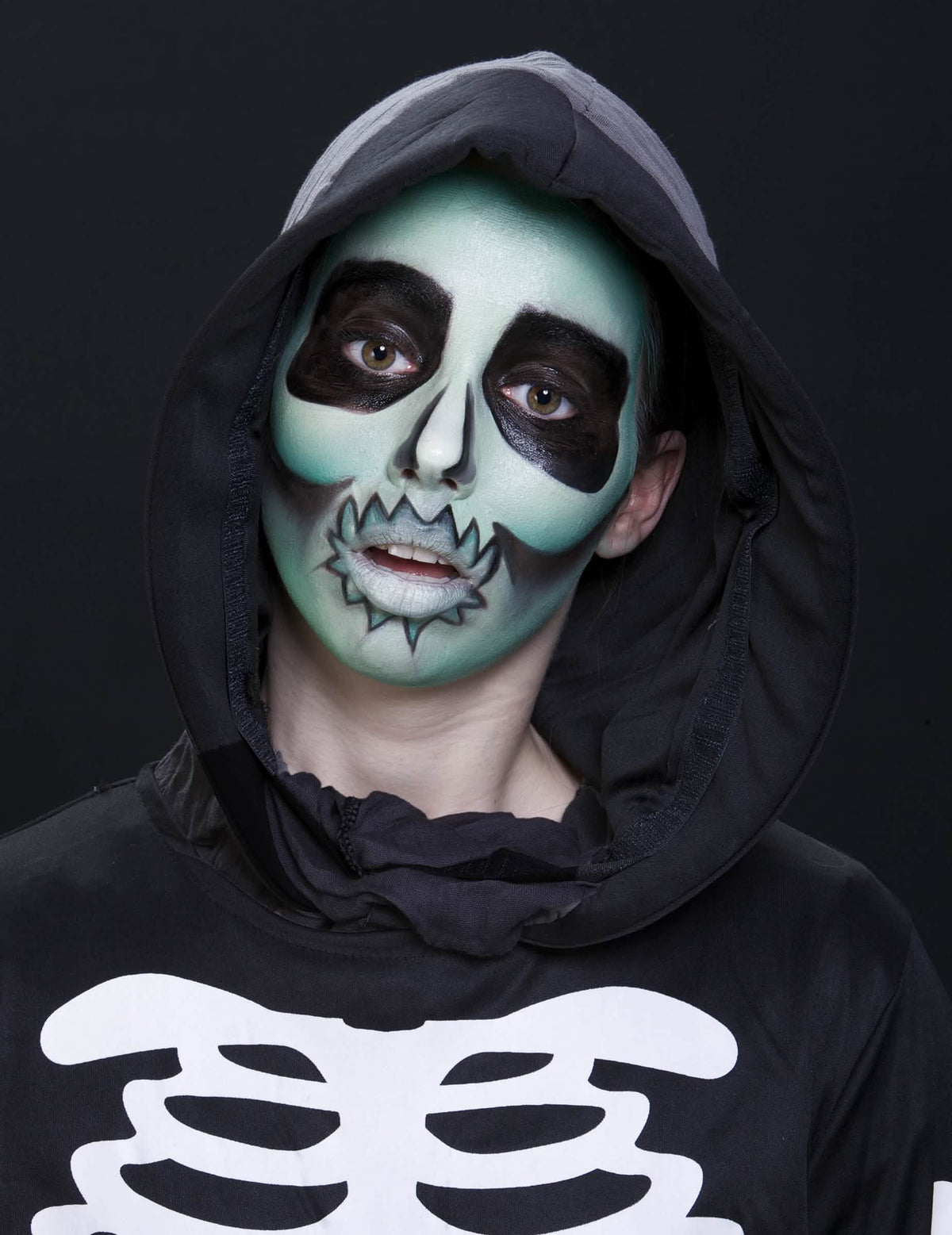 Gros plan sur le maquillage de squelette vert réalisé avec la crème phosphorescente maquillage fluo