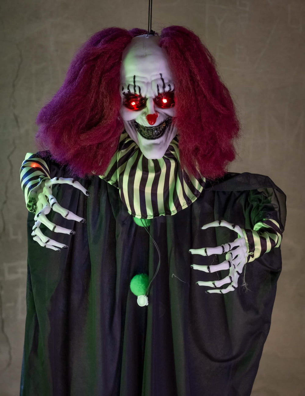 Détail des yeux rouges lumineux et des mains de la Décoration animée Clown Terrifiant