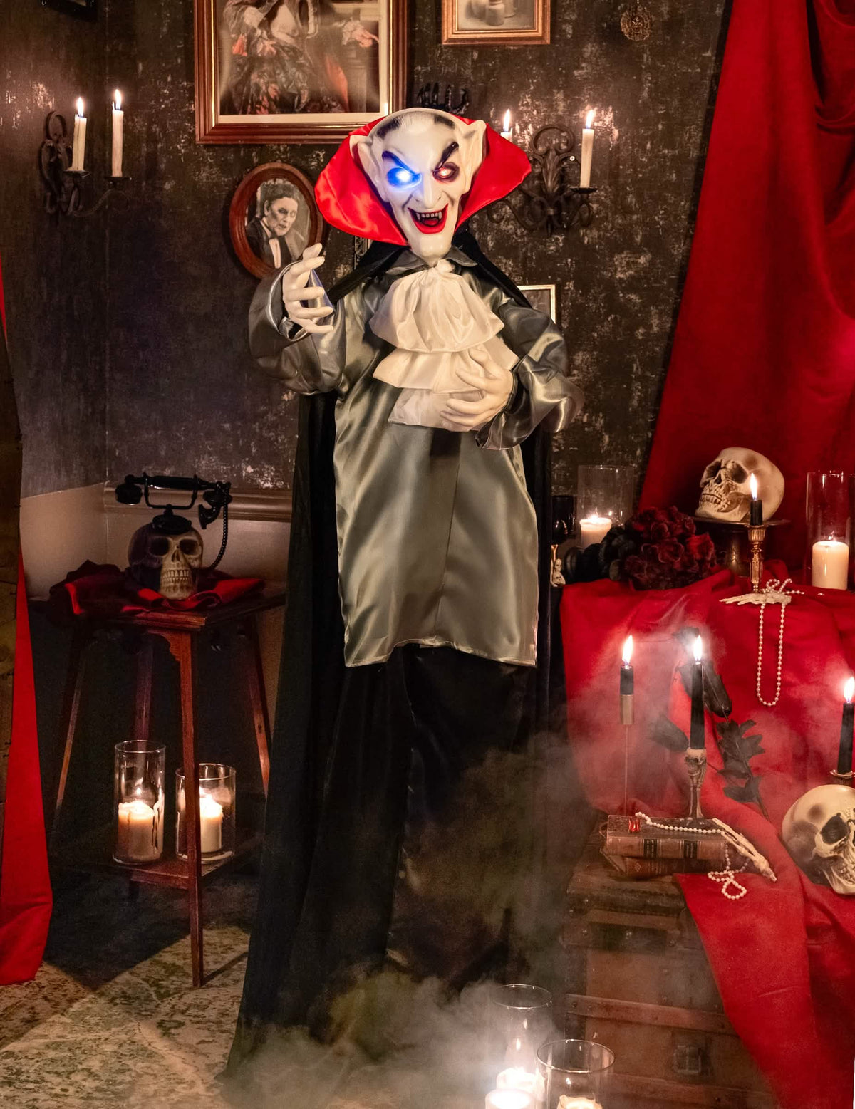 Mise en situation dans un décor d'Halloween de la décoration animée sonore et lumineuse Vampire Souriant
