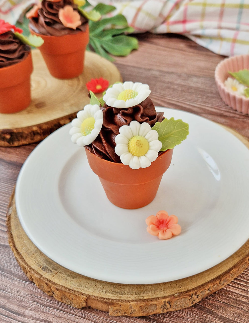 Mise en situation sur un gâteau des décorations en sucre marguerites et feuilles blanches et vertes