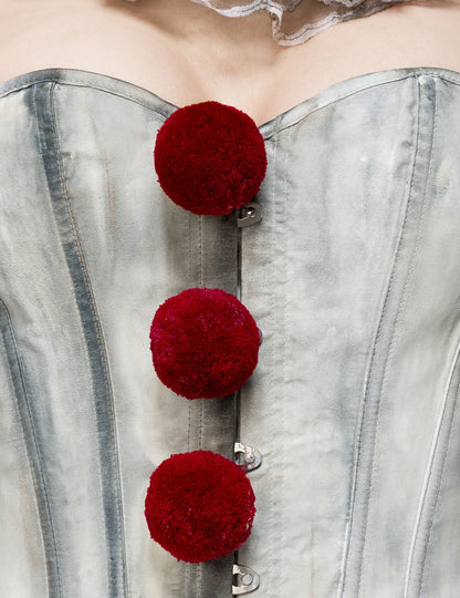 Gros plan sur les pompons rouges du bustier du déguisement clown terrifiant sexy luxe