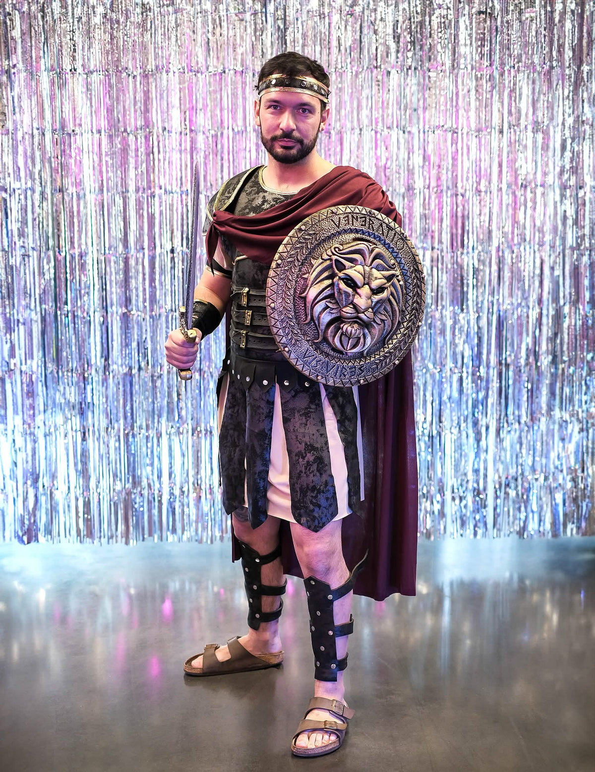 Mise en situation sur fond argenté brillant du déguisement de gladiateur romain pour homme