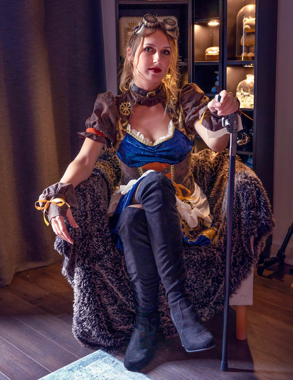 Vue de face du modèle assis avec accessoires du déguisement rétro futuriste steampunk