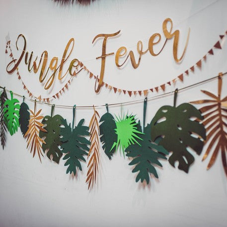 Détail des feuilles et du lettrage doré de la guirlande en carton jungle fever pour anniversaire tropical