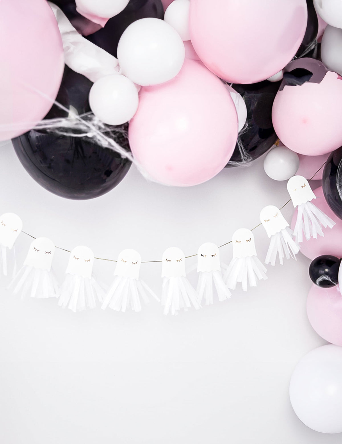 Mise en scène avec ballons de la guirlande en papier fantômes blanche et dorée à monter