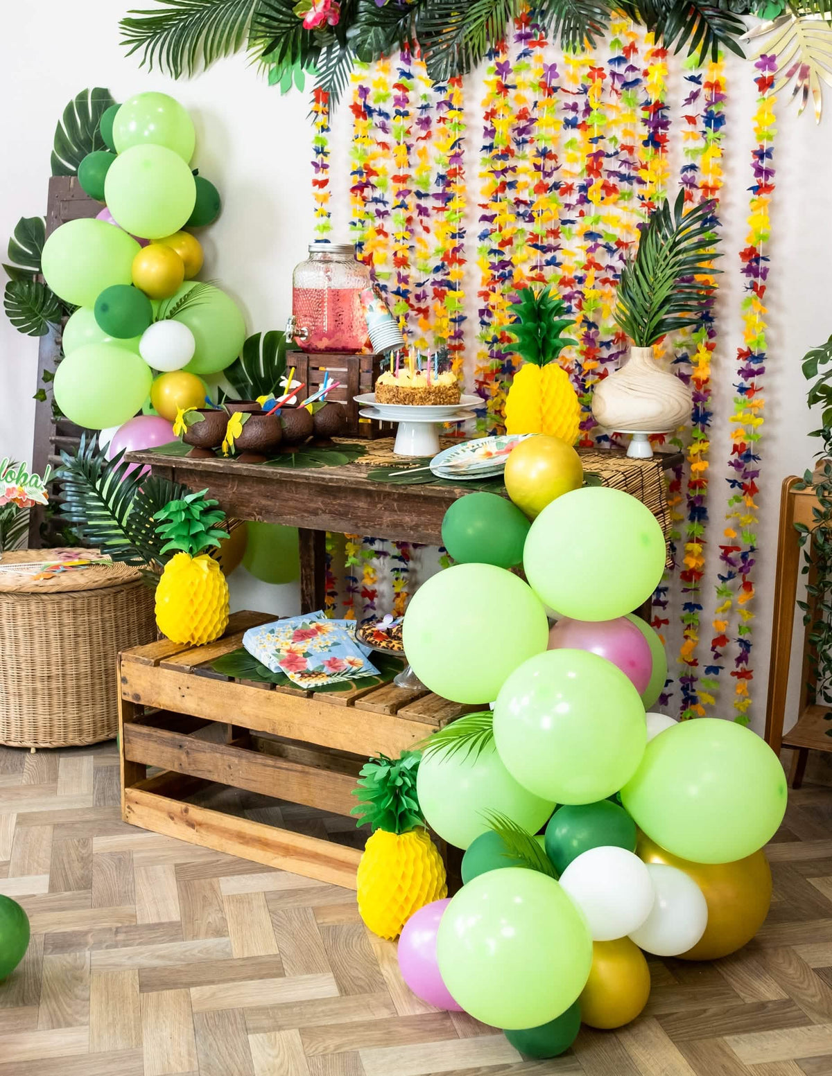 Ambiance festive du buffet avec le kit arche de 70 ballons tropicale et feuilles jungle