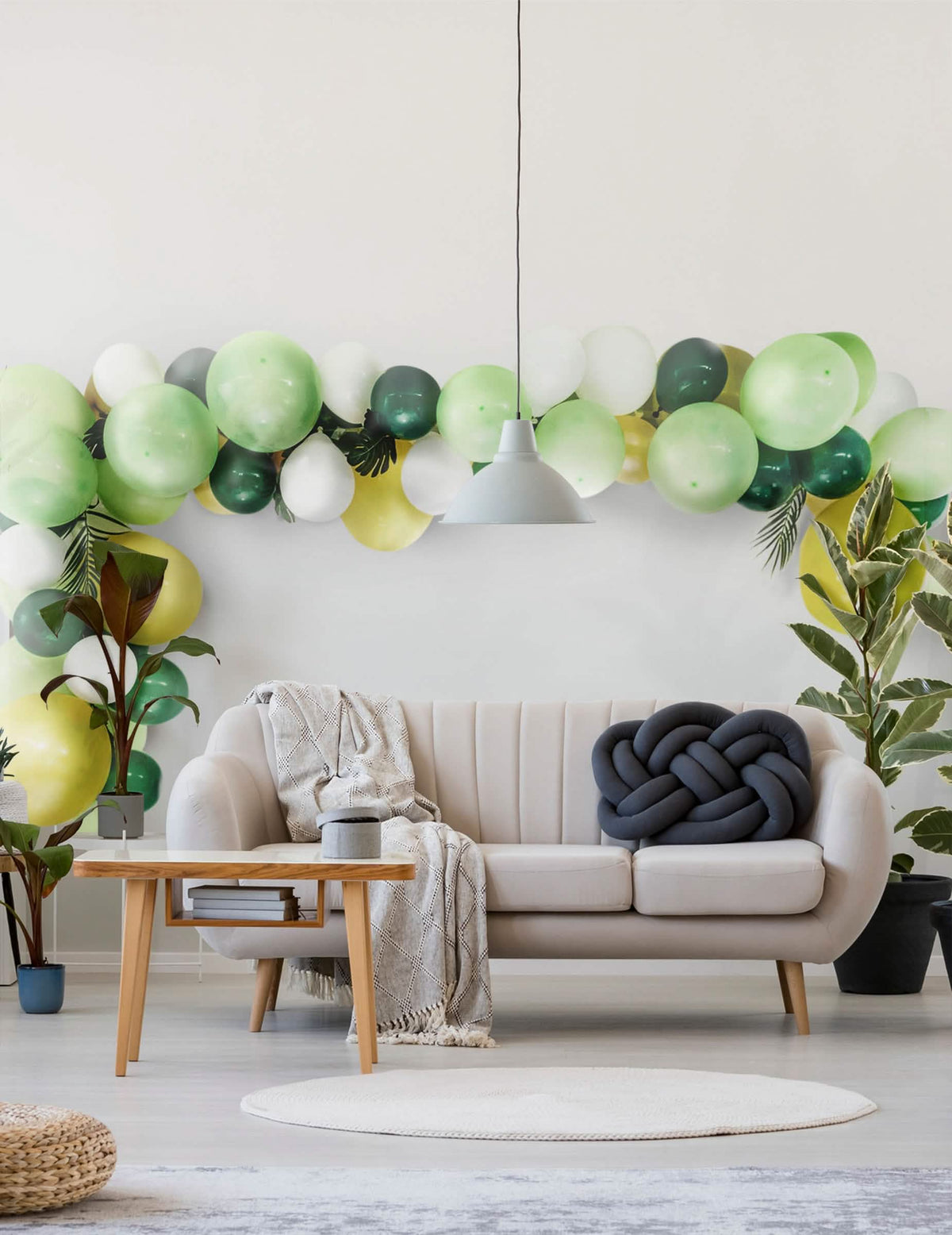 Mise en scène dans un salon du kit arche de 70 ballons tropicale et feuilles jungle