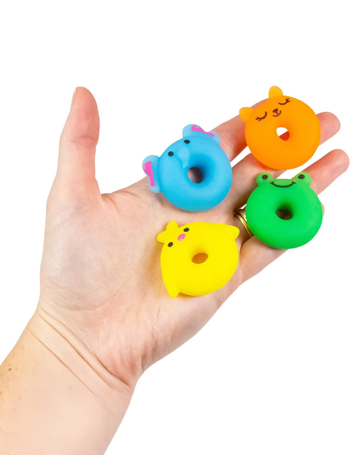 Détail de la taille dans la main du jouet mini animal squishy multicolore en forme de donut