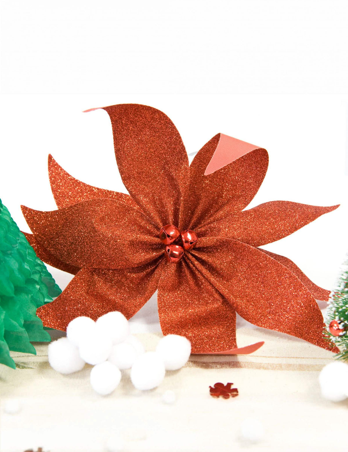 Gros plan sur les paillettes du nœud de poinsettia avec grelots pour décoration de table