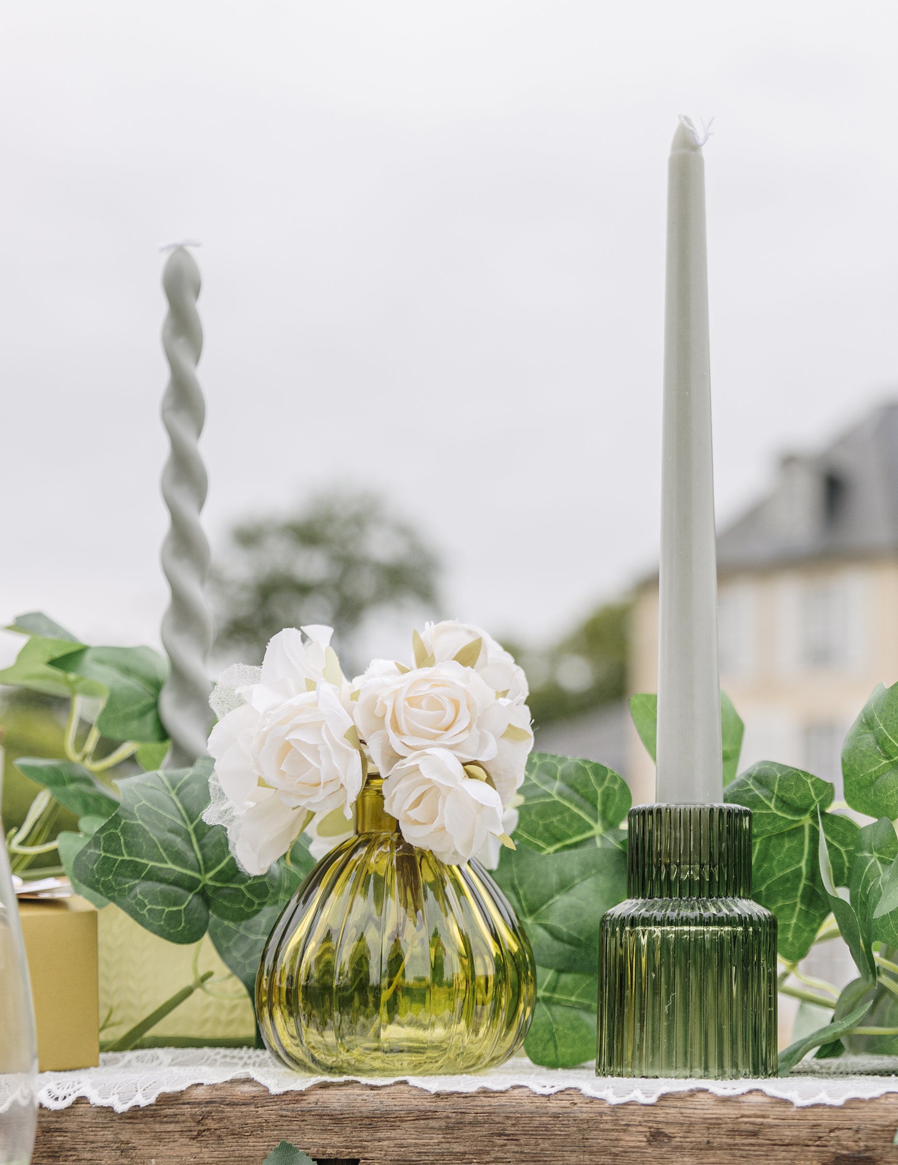 Mise en scène avec roses blanches du vase en verre strié pistache