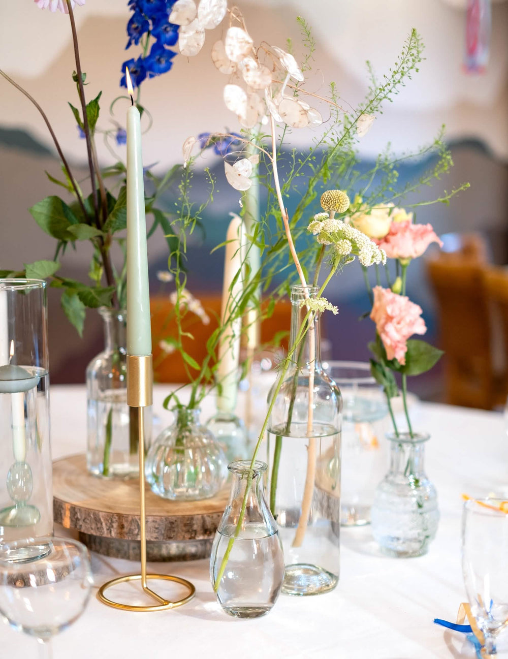 Blumenarrangement mit Kerzen in der Glas-Soliflorvase für Tischdeko